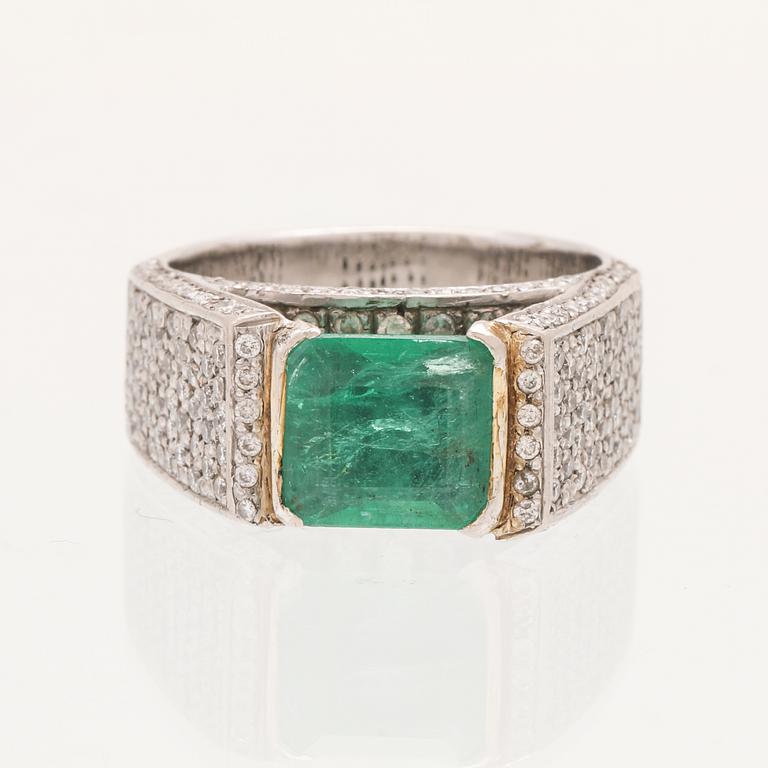 A 9K white gold ring with an emerald and brilliant cut diamonds.
