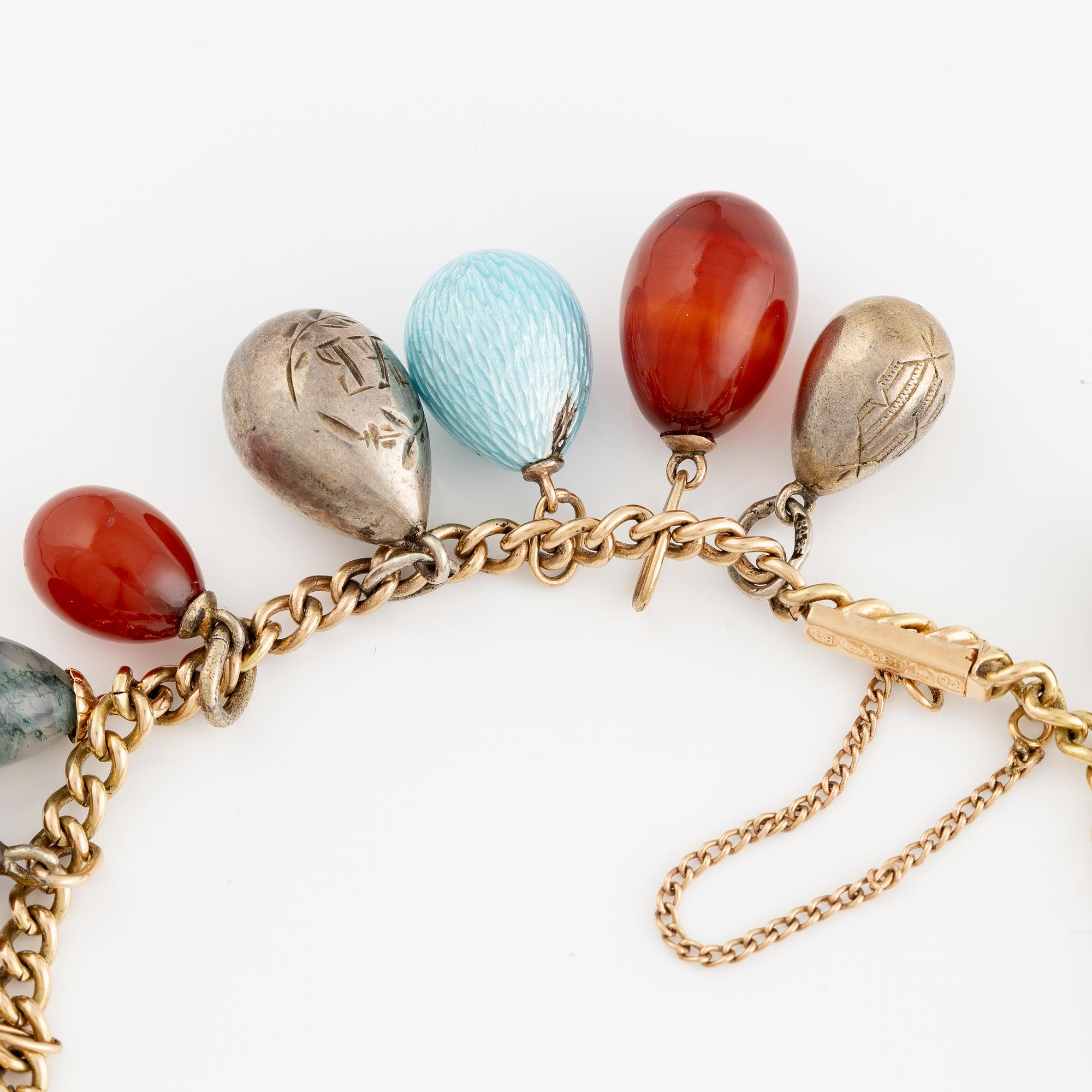 Bracelet with charms in the shape of eggs, the bracelet is 14K gold and 13 loose charms in the shape of eggs.