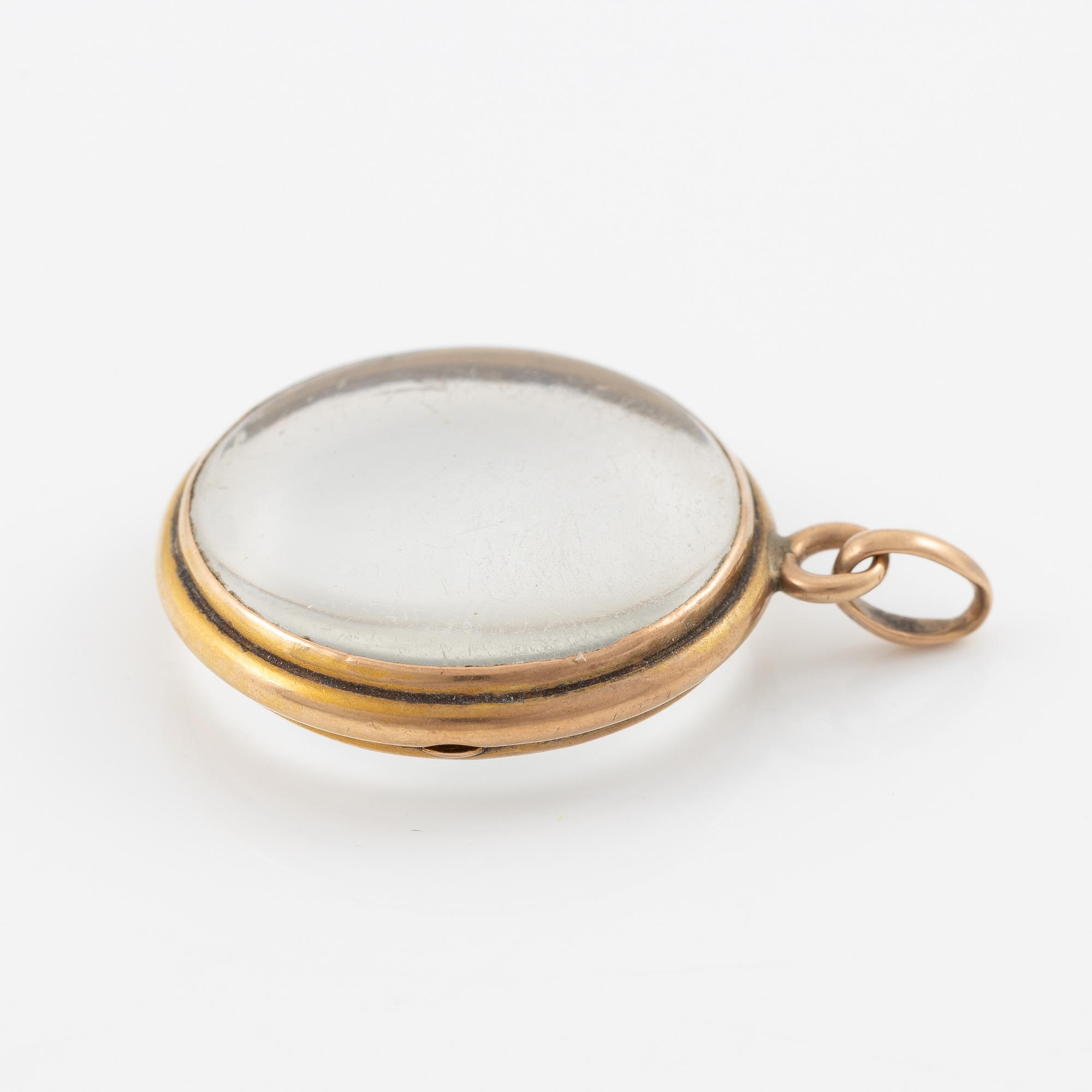 Medaljong, guld och glas.