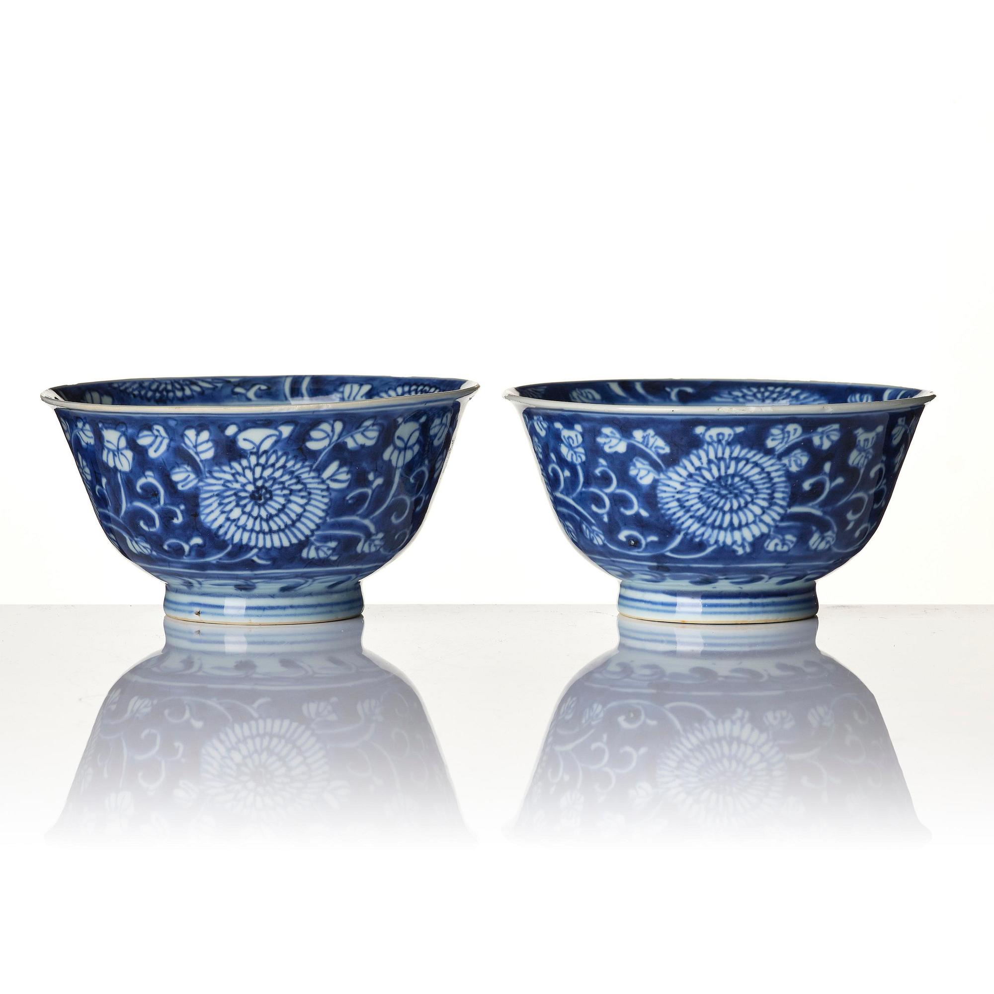 A pair of blue and white reverse decorated floral bowls, Qing dynasty, Kangxi (1662-1722).
