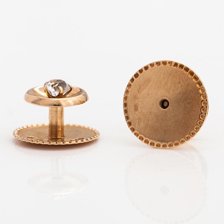 Elis Kauppi,  A pair of 14K gold buttons with rock crystals to a white tie shirt. Kupittaan kulta, Turku.