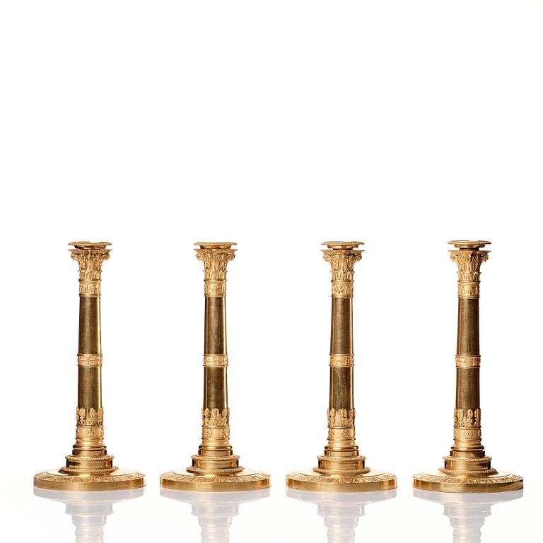 A set of four Empire presumably Russian candlesticks in gilded bronze.