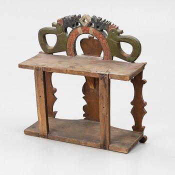 A Swedish carved and painted folk art shelf from Hälsingland, 18th / 19th century.