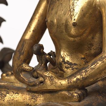 A large Nepalese gilt bronze buddha on a throne with mandorla, 18/19th Century.