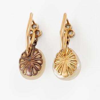 A pair of earrings in 18K gold with button-shaped saltwater pearls and old-cut diamonds.