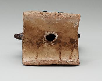 A turquoise and purple glazed roof top tile in the shape of a fish, Ming dynasty.