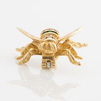 Brooch 18K gold set with round faceted emeralds and rubies, as well as round brilliant-cut diamonds.