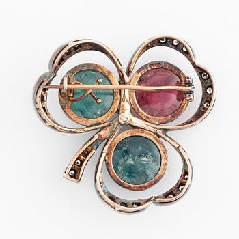 A silver and 18K gold brooch set with cabochon-cut tourmalines.