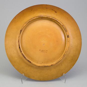 A wall plate by Adolf Neumann, Rörstrand, signed on verso 1884.