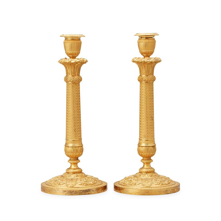 A pair of French Empire early 19th century gilt bronze candlesticks.