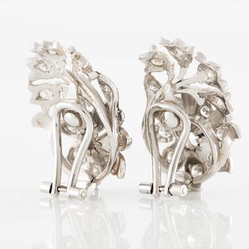 A pair of earrings in 18K gold set with round brilliant-cut diamonds.