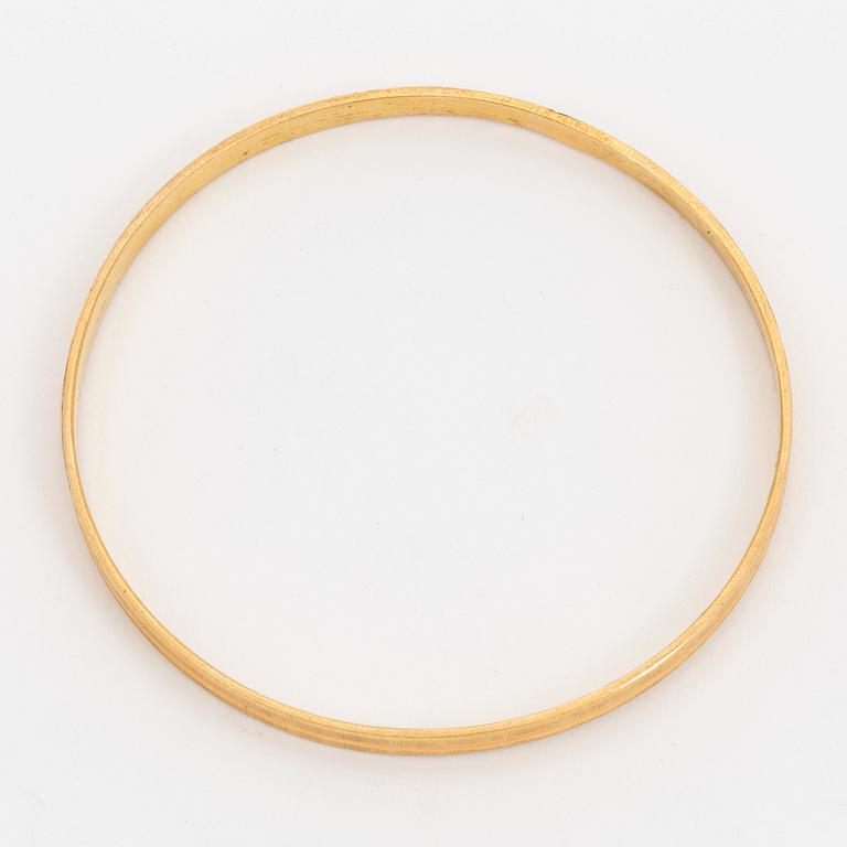 A bangle with a textured surface. 14K gold.