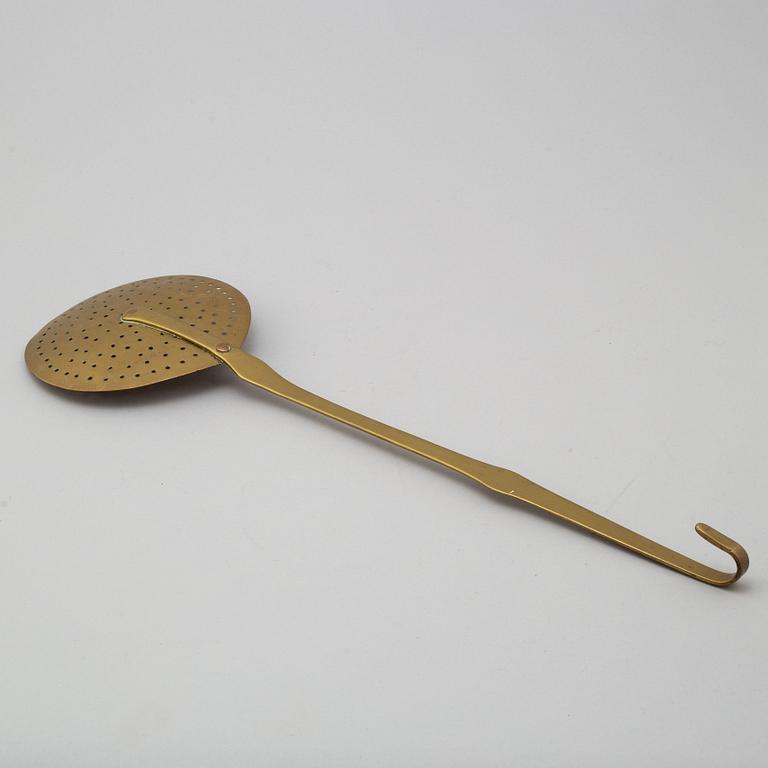 An 18th century brass strainer.