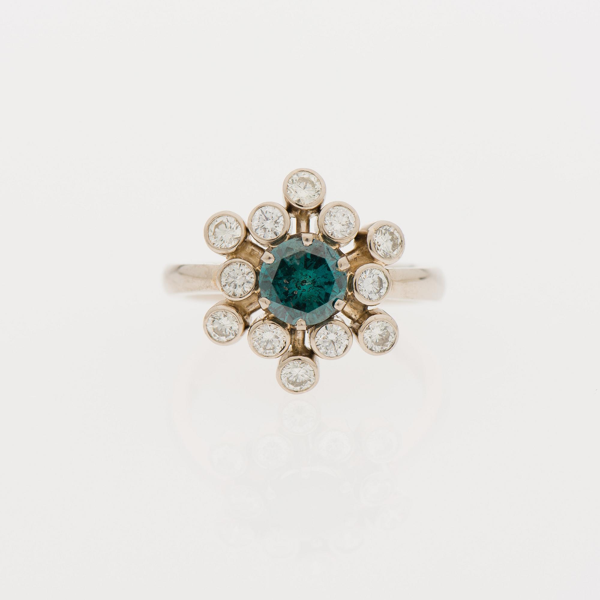 RING, 18K guld med briljantslipad, behandlad blå diamant samt mindre diamanter. Erkki Nupponen, Finland. Vikt 5,0 g.