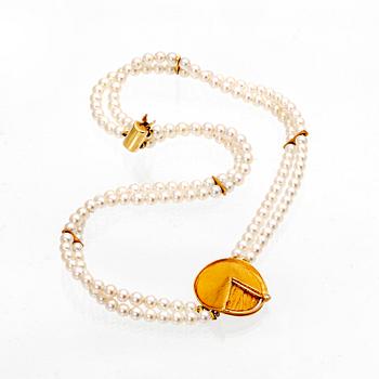 A necklace of cultured pearls and pendant in 18K gold with a brilliant cut diamond.
