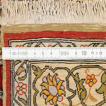 A silk and metal Hereke rug, c. 86 x 52 cm.