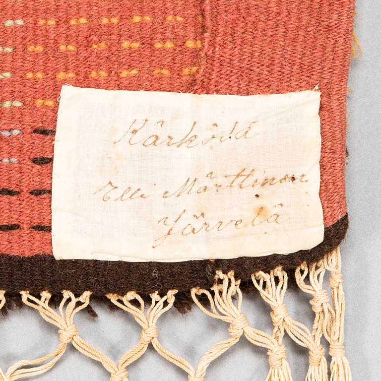 Tuntematon taiteilija, keinutuolimatto, 1930-luku. Noin 190x48 cm.