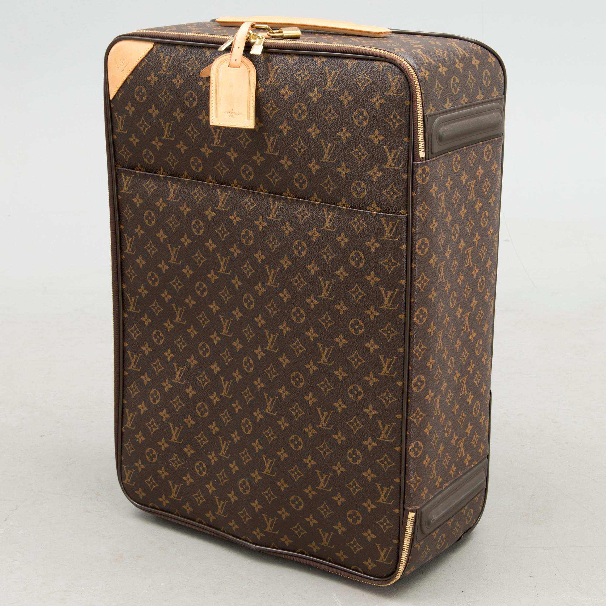 A Monogram Canvas Pégase 65 Suitcase with a Protective Cover.