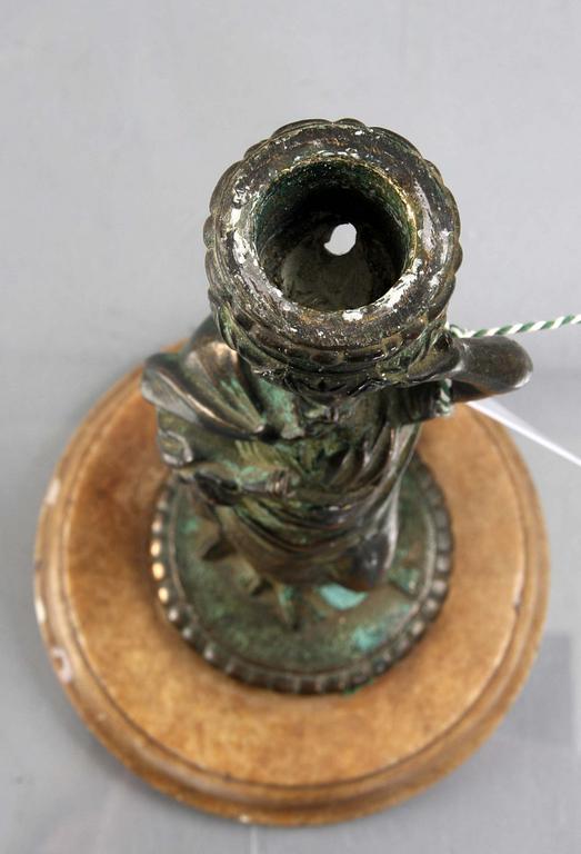 LJUSSTAKE, 1900-tal, patinerad brons med fot av marmor.