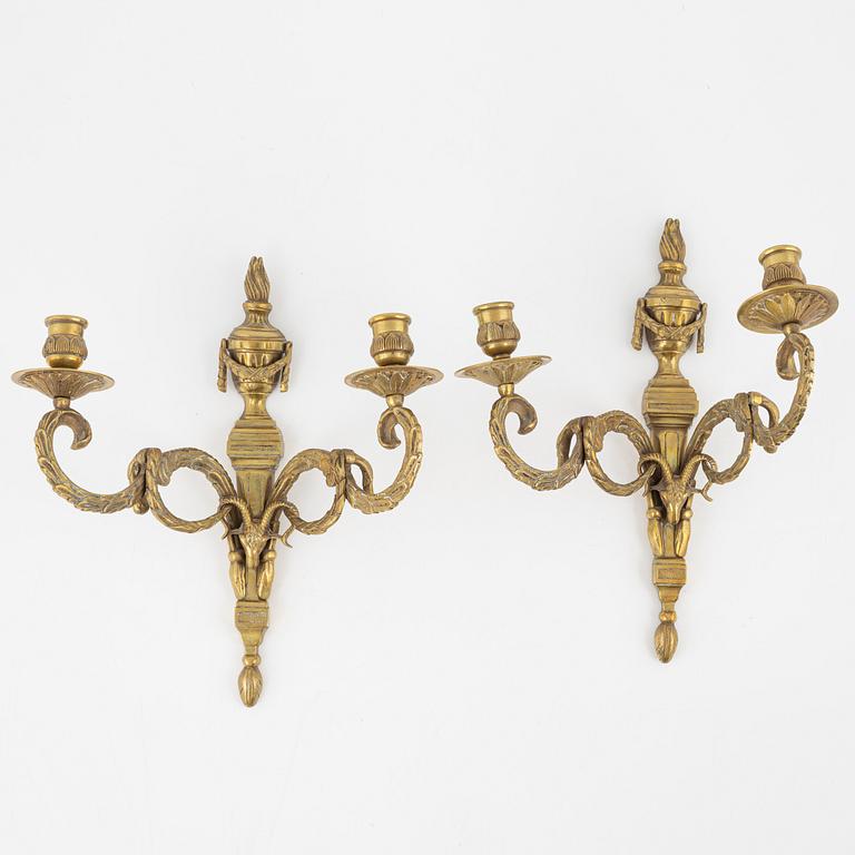 A pair of brass Louis XVI-style two-light wall lights, early 20th Century.