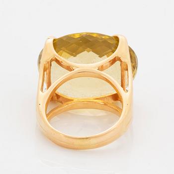 An 18K gold ring set with a faceted lemon quartz.