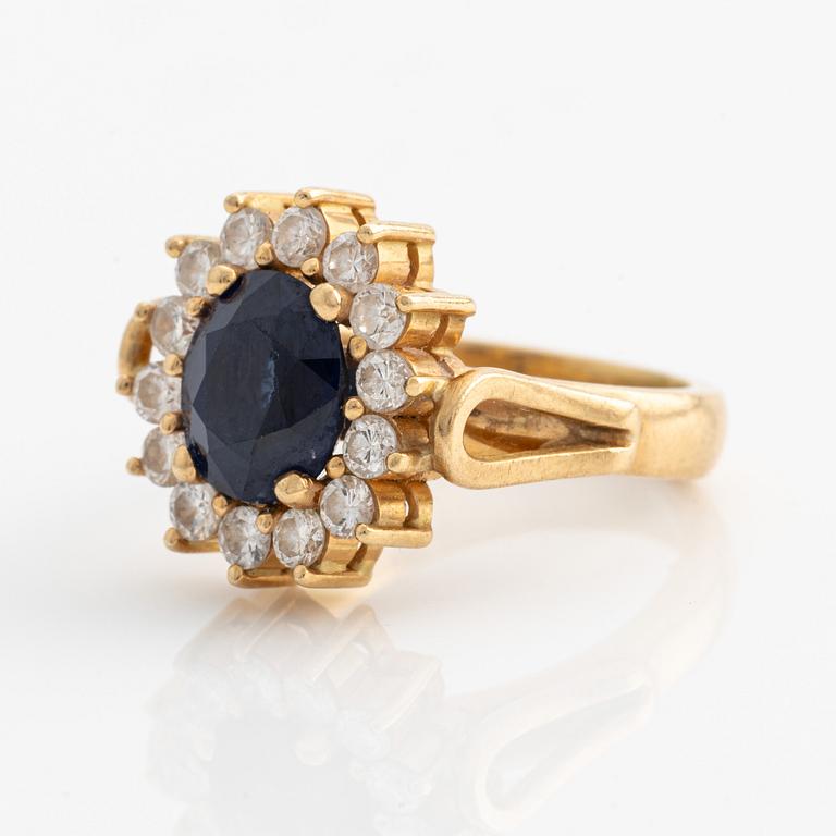 Ring in 18K gold with a faceted sapphire and round brilliant-cut diamonds.