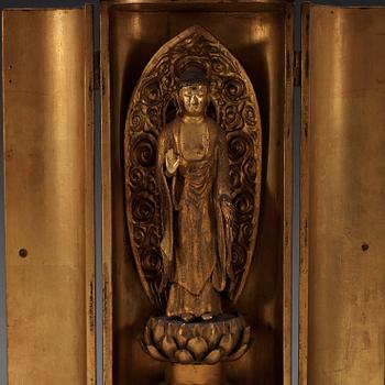 A Japanese gilt wooden figure of standing Buddha in a lacquer shrine, Meiji (1868-1912).