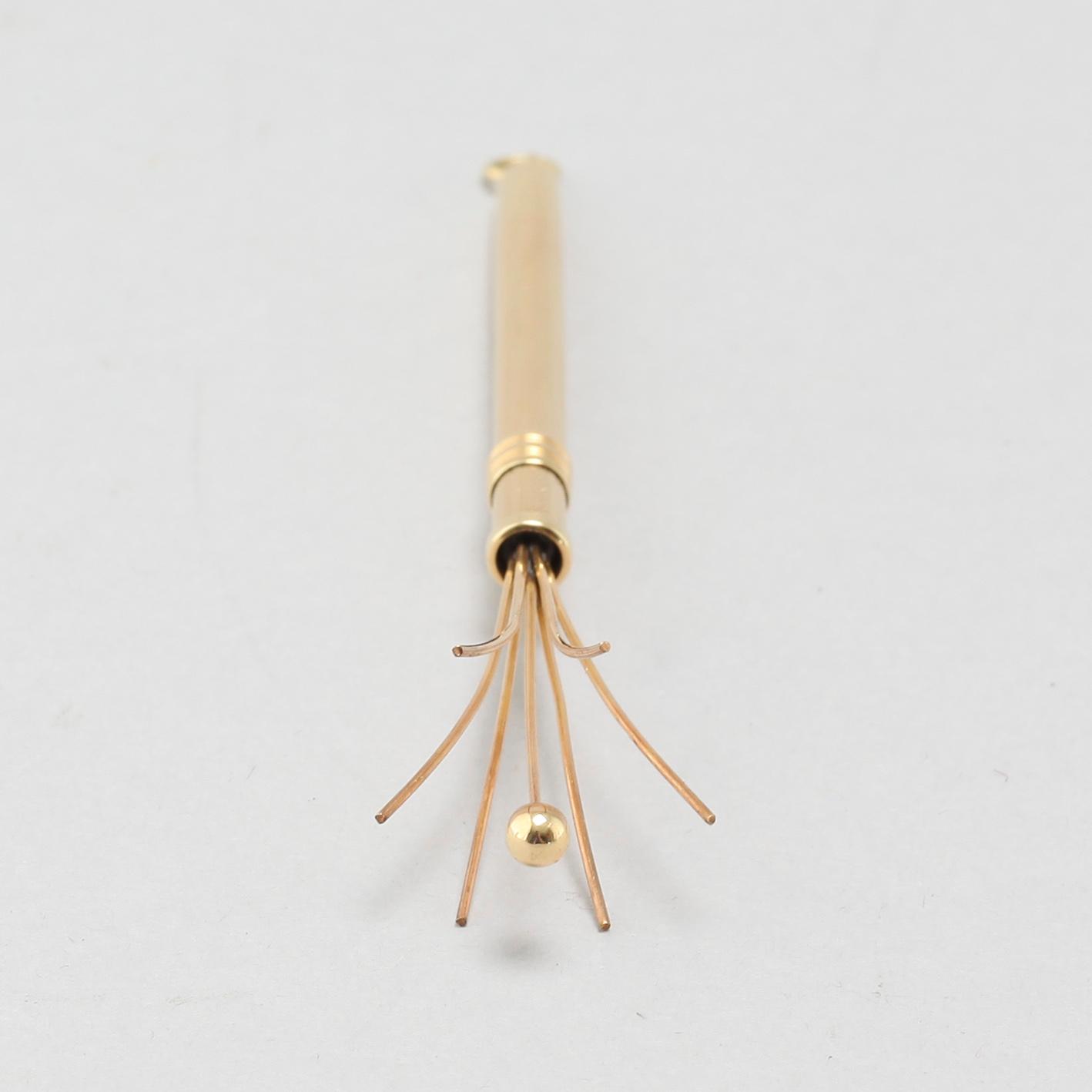 An 18k gold champagne whisk.