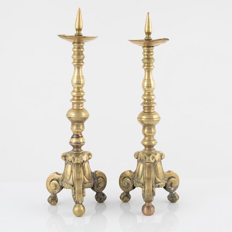 A pair of brass candle sticks, around 1700.
