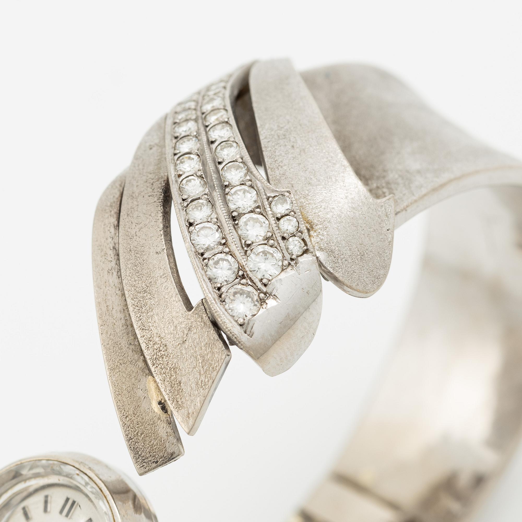 Aftonklocka/armring, Bo Dolk, 18K vitguld med briljantslipade diamanter, 1970-tal.
