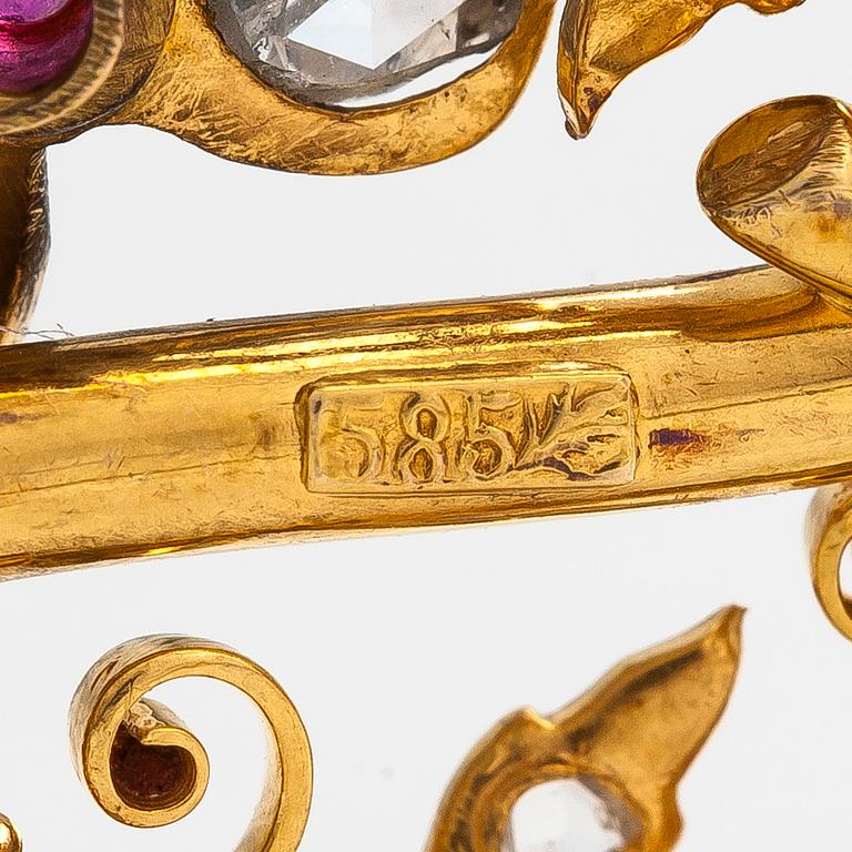 A 14K gold brooch set with rose-cut diamonds and a ruby.