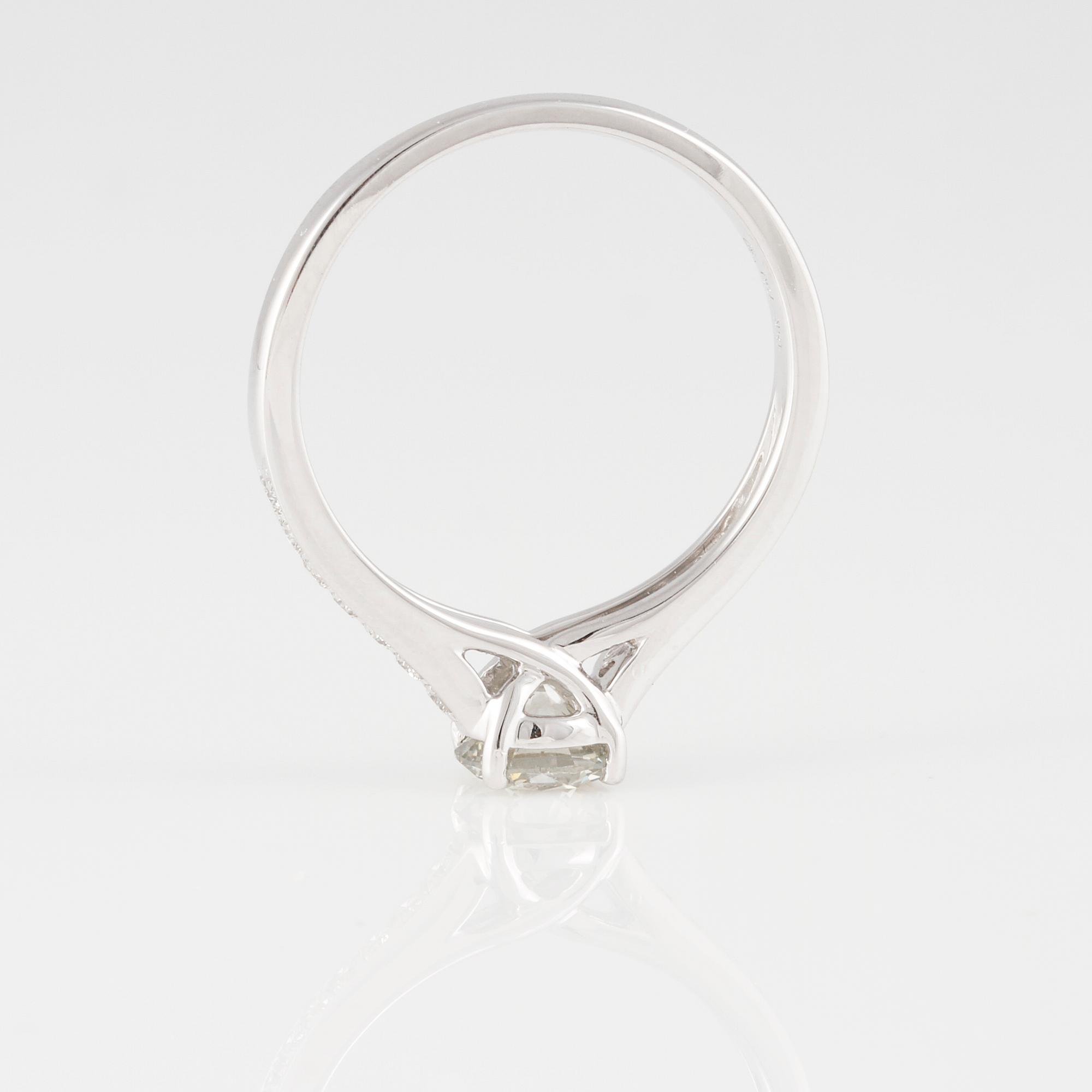 RING, 18K vitguld med briljantslipad diamant ca 0.70 ct samt små briljantslipade diamanter ca 0.15 ct. Vikt 2,9 gram.