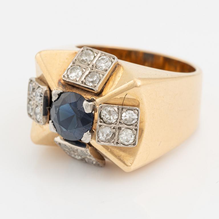 An 18K gold ring set with a faceted sapphire and diamonds.