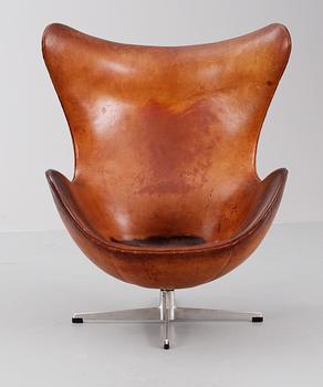 An Arne Jacobsen brown leather 'Egg chair' with ottoman, by Fritz Hansen, Denmark 1963.