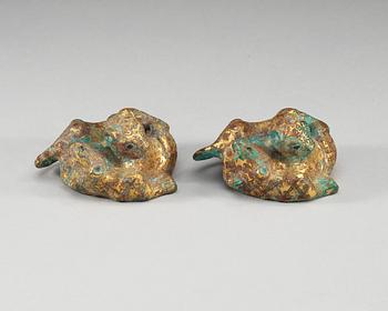 A pair of gilt bronze archaistic weights.