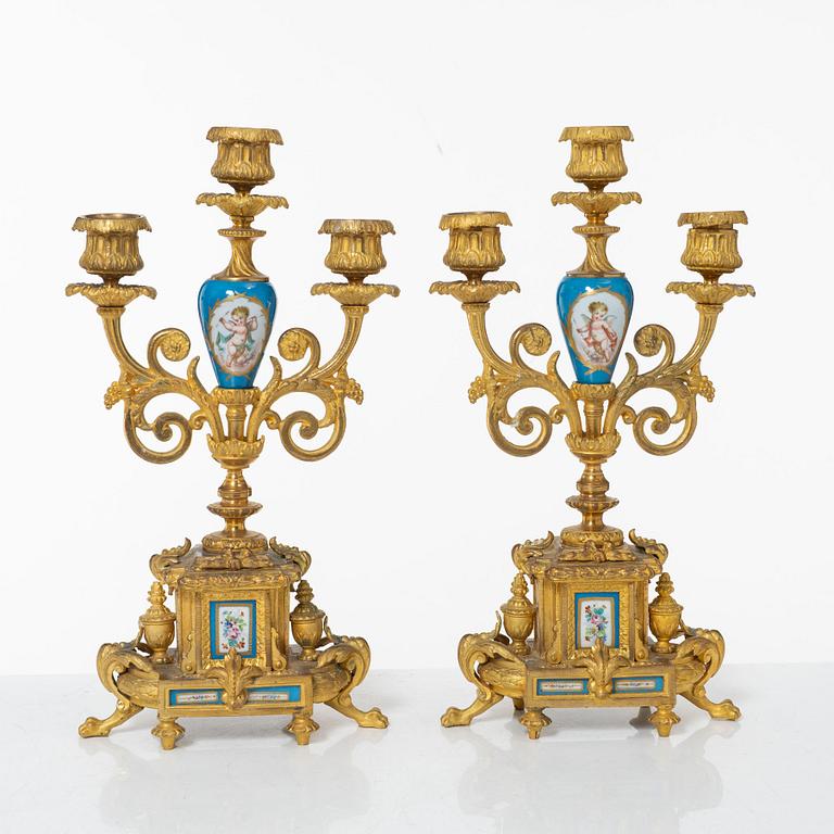 A French Louis XVI-style mantel clock and a pair of candelabra, late 19th Century.