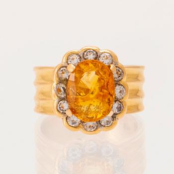 A 22K gold carmosé ring with an oval faceted yellow sapphire and round brilliant-cut diamonds.