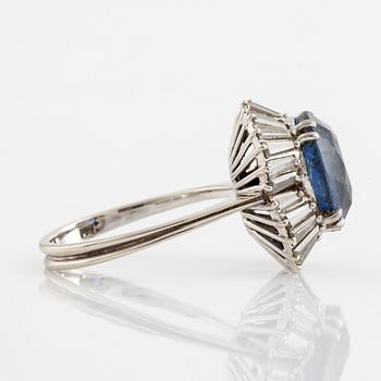 An 18K gold ring set with a faceted sapphire and tapered baguette-cut diamonds.