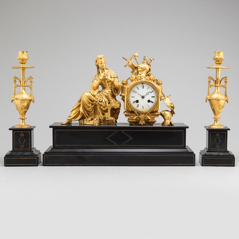 A late 19th century table clock and a pair of candlesticks.