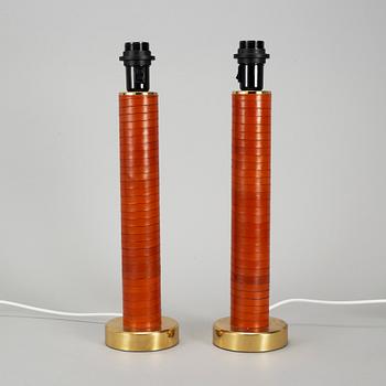 A pair of brass and leather table lamps.