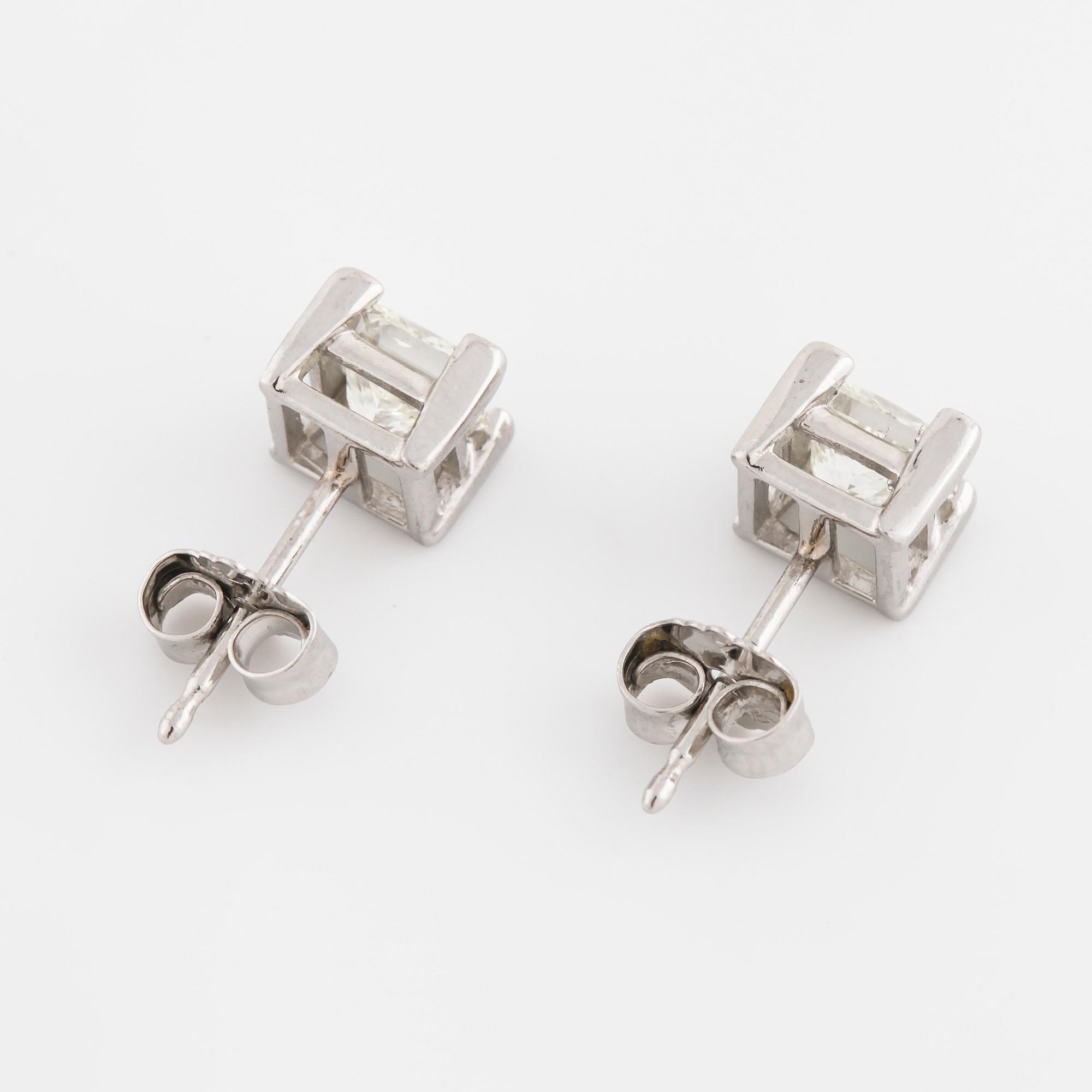A pair of princess cut diamond earrings.