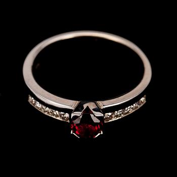 RING, vitguld 14K, fasettslipad granat 0,49 ct, briljantslipade diamanter diamanter tot. 0,21 ct. Vikt 4,7 g.