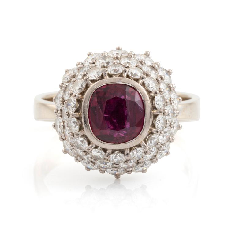 Ring 18K guld med en fasettslipad rubin samt runda briljantslipade diamanter.
