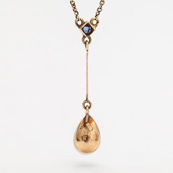 An 18K gold neckalce with a sapphire and cultured pearl.