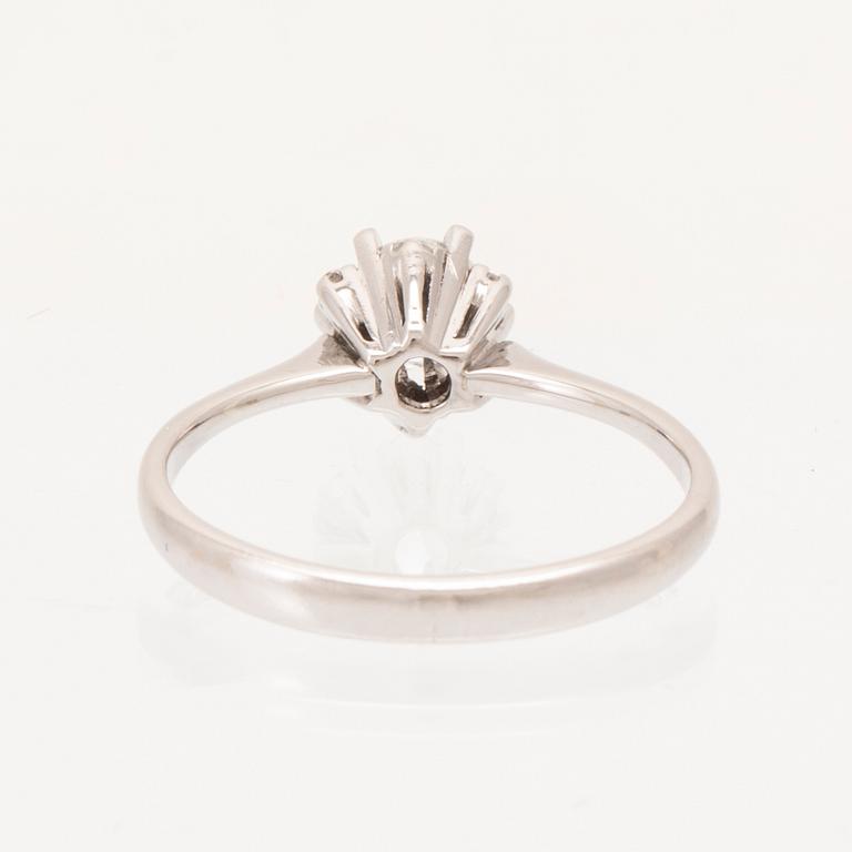 An 18K white gold ring set with a round brilliant cut diamond and single cut diamonds.