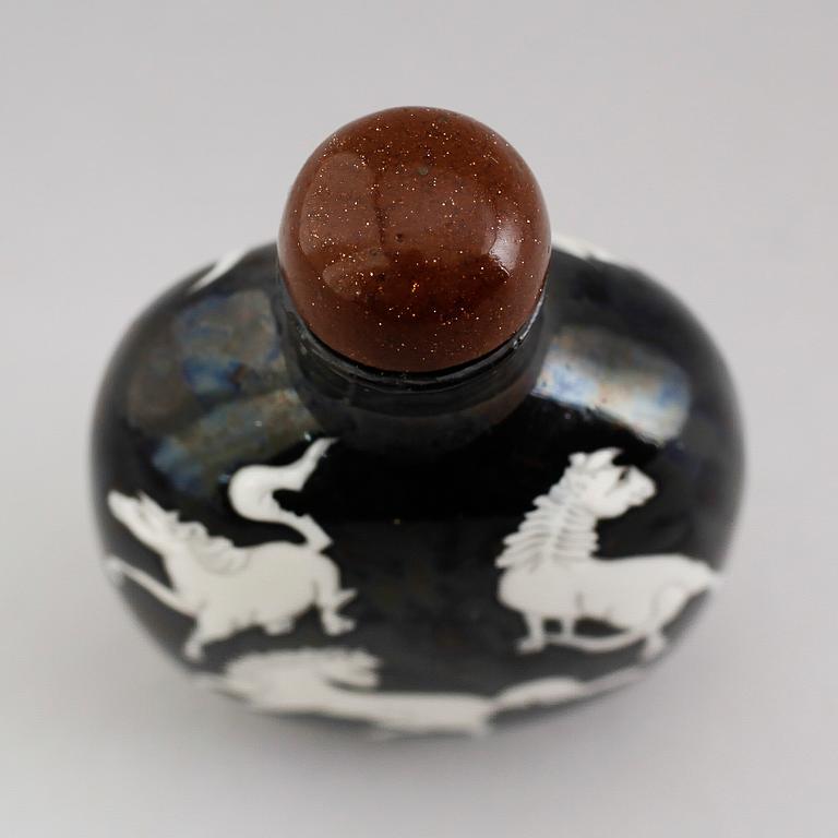 An enamelled porcelain snuff bottle with stopper, Qing dynasty (1644-1912).