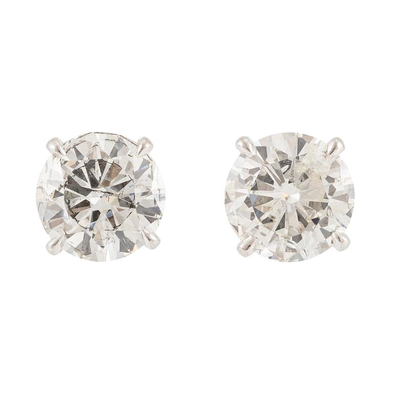 A pair of earrings in 18K white gold set with two round brilliant-cut diamonds.