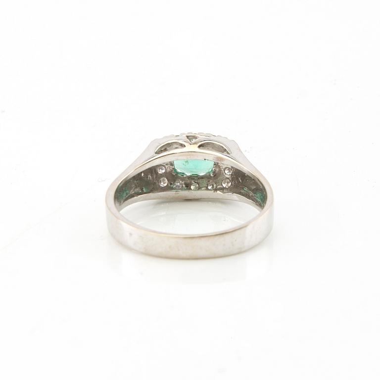 Ring in 18K white gold with an oval faceted emerald and round brilliant-cut diamonds.