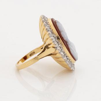 An 18K gold ring set with a hardstone cameo.