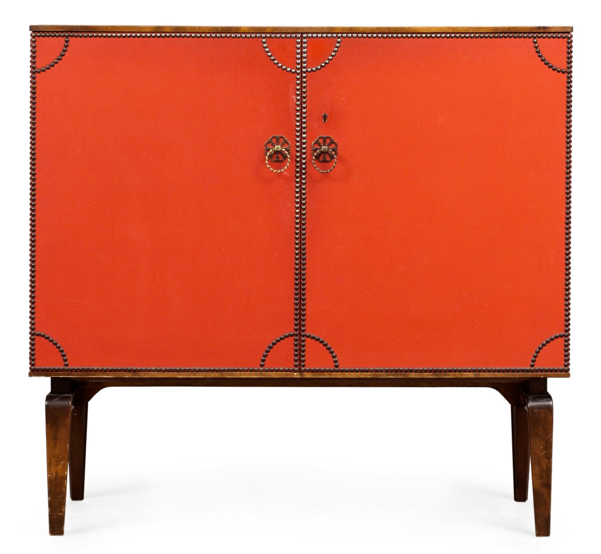An Otto Schulz cabinet on stand with artificial red leather and brass details on a stained oak and birch stand, by Boet, Gothenburg, probably 1950's.